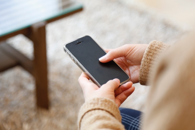東京の質屋にアイフォン(iPhone)を質入れするなら「かづさや質店」 - iPhoneを手に持つ様子